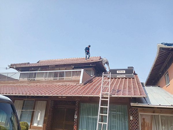 屋根の調査をする建築士